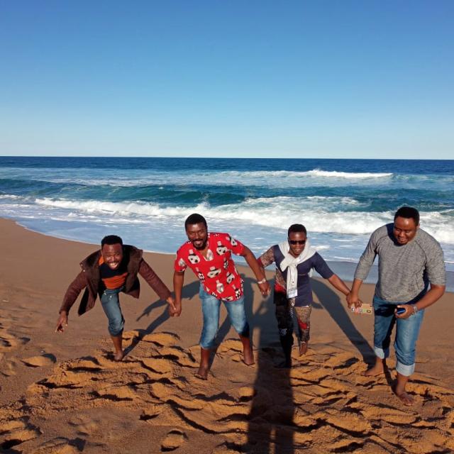 Paul, Tatenda, Adedotun and Stephen running away from the ocean tides